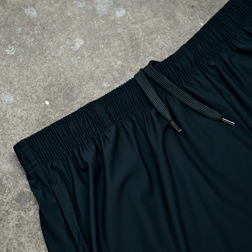 Black pants with drawstring on a concrete surface